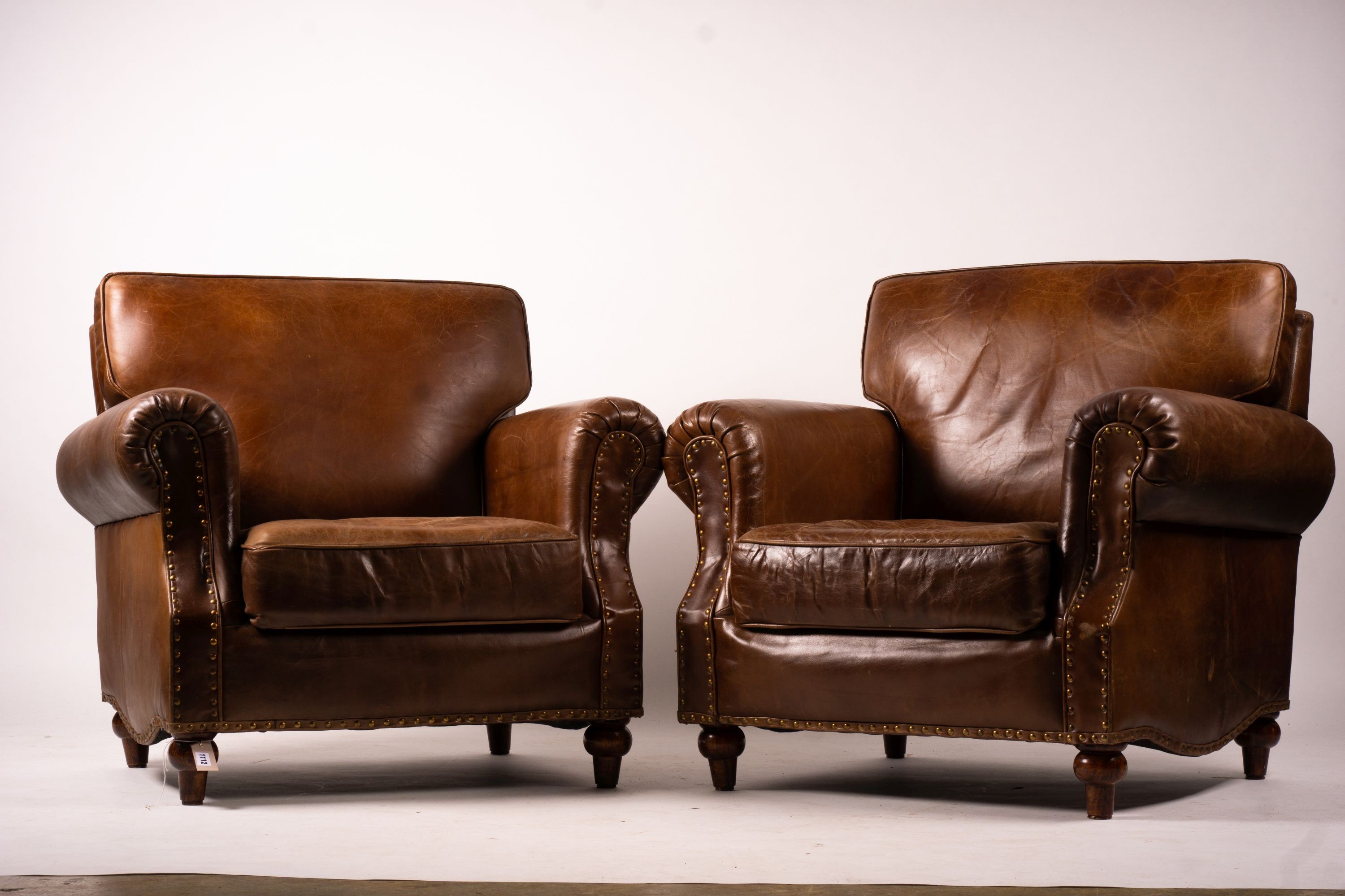 A pair of brown leather club armchairs, width 96cm, depth 80cm, height 90cm